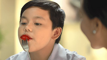 NutriAsia - kid eating hotdog